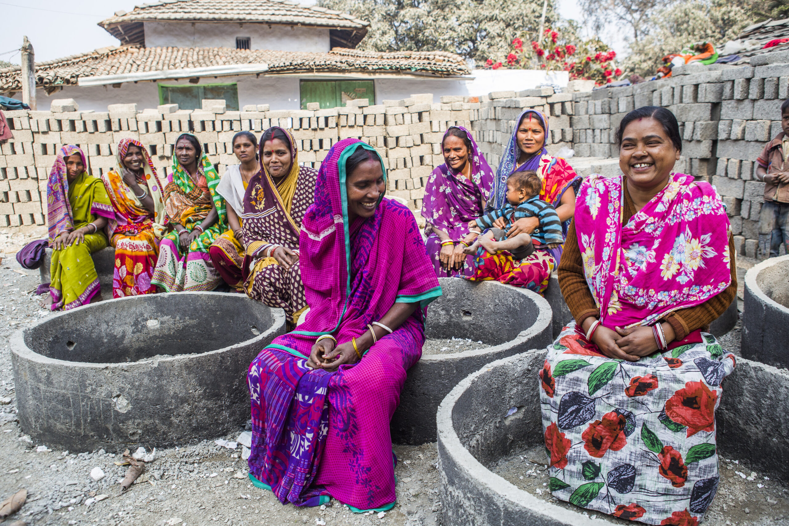 A photo of a group of women sat down outside.